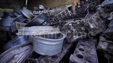 破旧汽车的金属部件正躺在大型机库、旧驼峰和发动机的废金属堆中